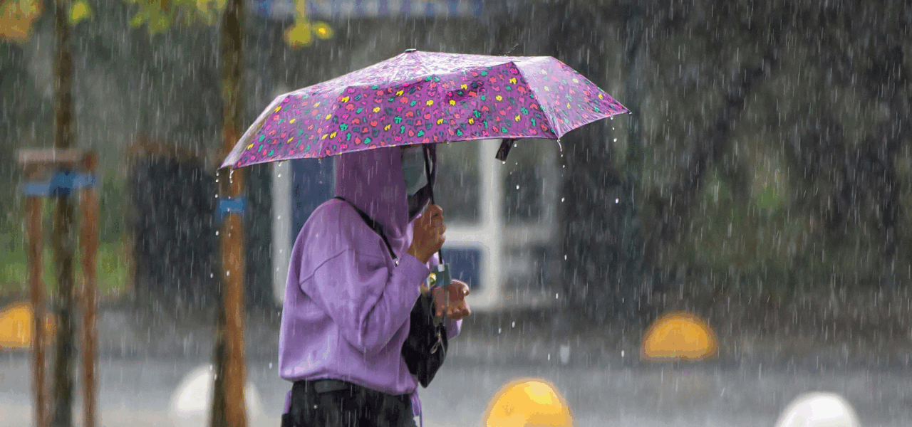 persona caminando con un paraguas bajo un temporal de lluvia